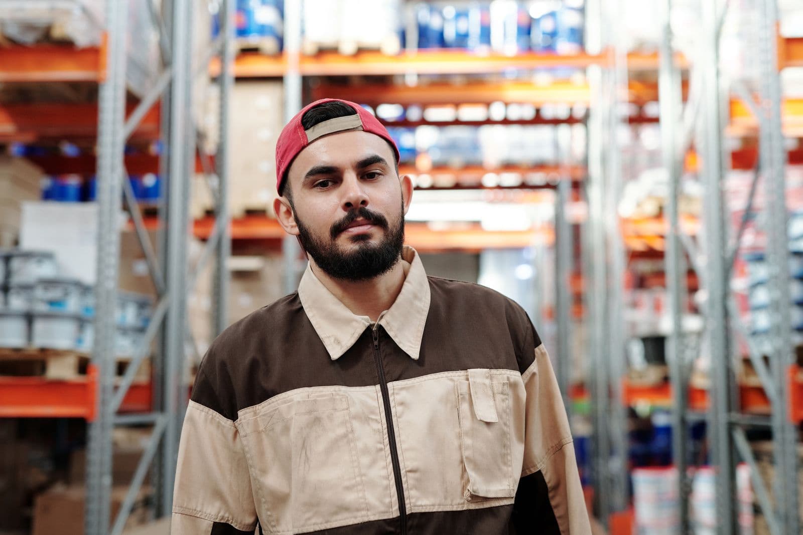 A worker recording stock on a tablet between warehouse racks